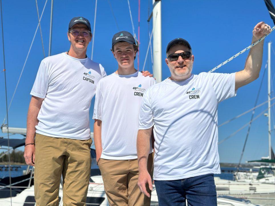 Todd Ellis, President of National Wealth Management (Crew), and Captain, Shane Theunissen and his son Jack (Crew) onboard the sailing vessel Footloose IV.